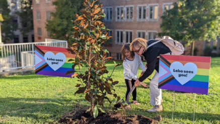 Families ceremoniously add dirt to the tree planted in dedication to the Mt. Lebanon students with ally yard signs on either side.